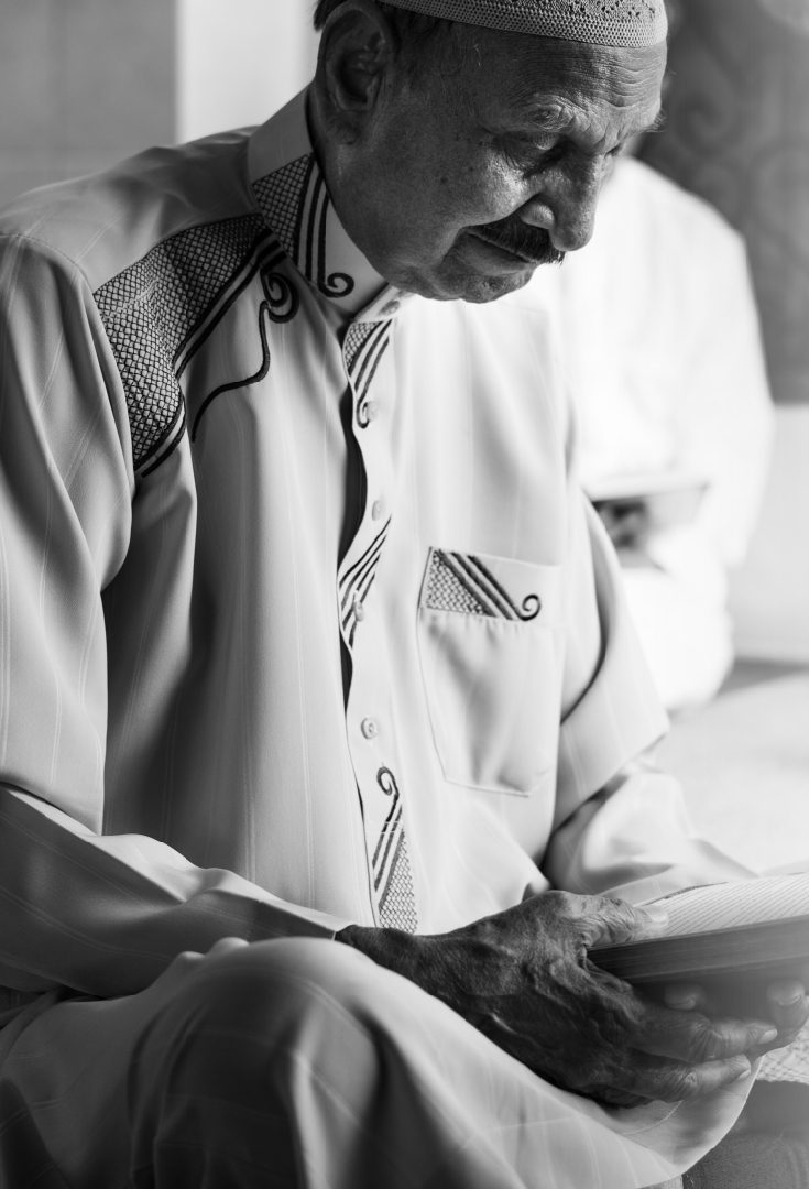 Homme âgé lisant le Coran